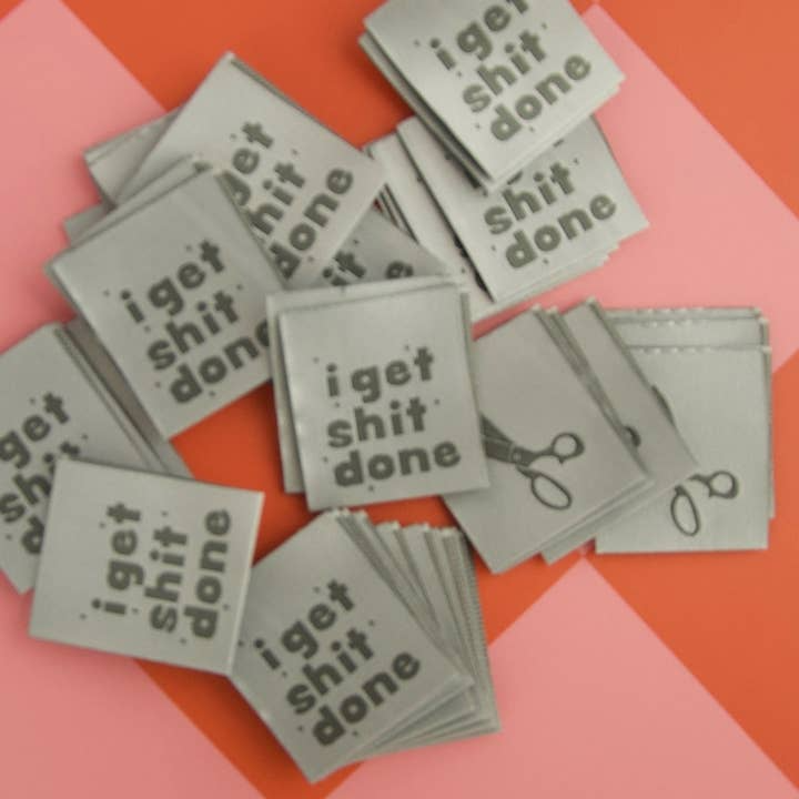 Stack of gray cards with 'I get shit done' text on a pink and orange background