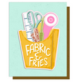 Card with a yellow bag labeled 'Fabric & Fries' containing fabric scissors, a ruler, and a spool of thread on a light blue background.