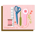 Illustration of sewing tools on a pink background with 'Happiness is' text.