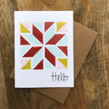 Greeting card with geometric design and 'Hello' text on a wooden surface