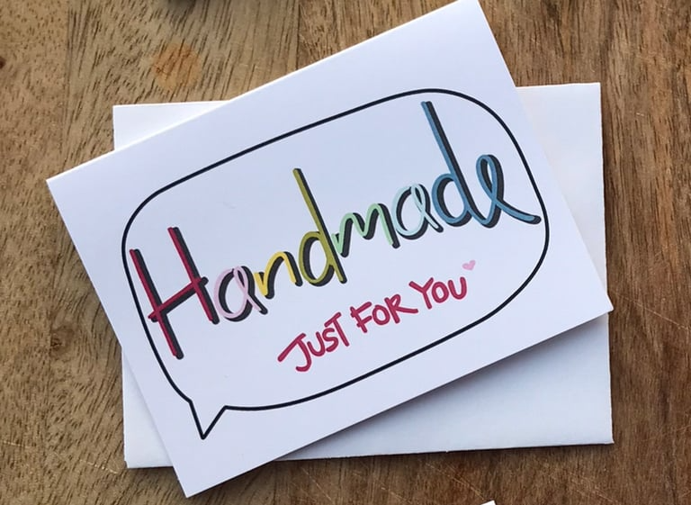 Card with 'Handmade Just For You' text on a wooden surface