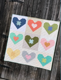 Quilt with colorful heart patterns on a wooden surface