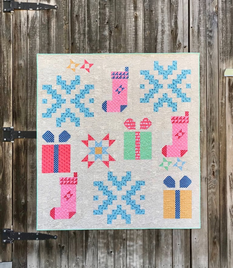 Quilt with Christmas-themed patterns on a wooden door background