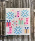 Quilt with Christmas-themed patterns on a wooden door background