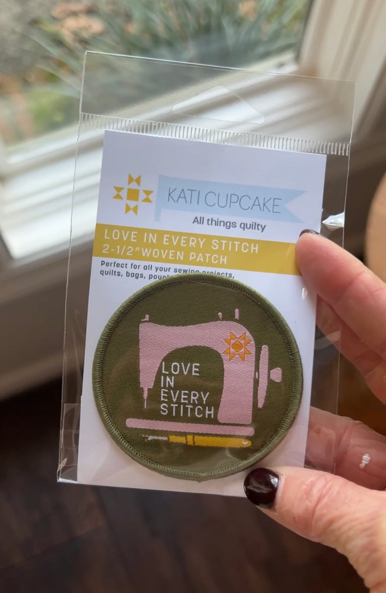 Kati Cupcake patch with sewing machine design held by a hand