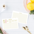 Two recipe cards on a white surface with lemons and spoons in the background.