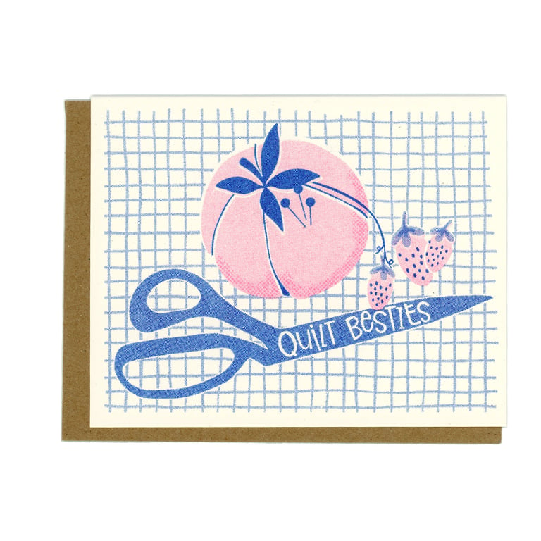 Card with blue scissors, pink flower, and text 'Quilt Besties' on a grid background