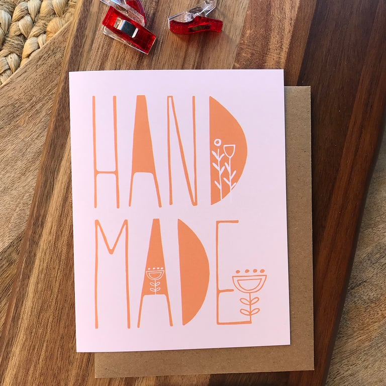 Card with 'Hand Made' text on a wooden surface