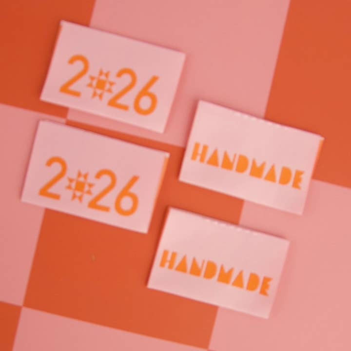 Four white cards with orange text '2#26' and 'HANDMADE' on a pink and orange checkered background.