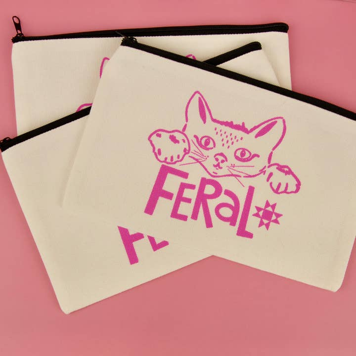 Canvas pouches with a cat illustration and 'Feral' text on a pink background